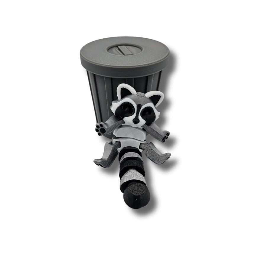 Gray and black articulated raccoon figurine in trash can