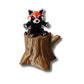 Red panda figurine with striped tail on tree stump
