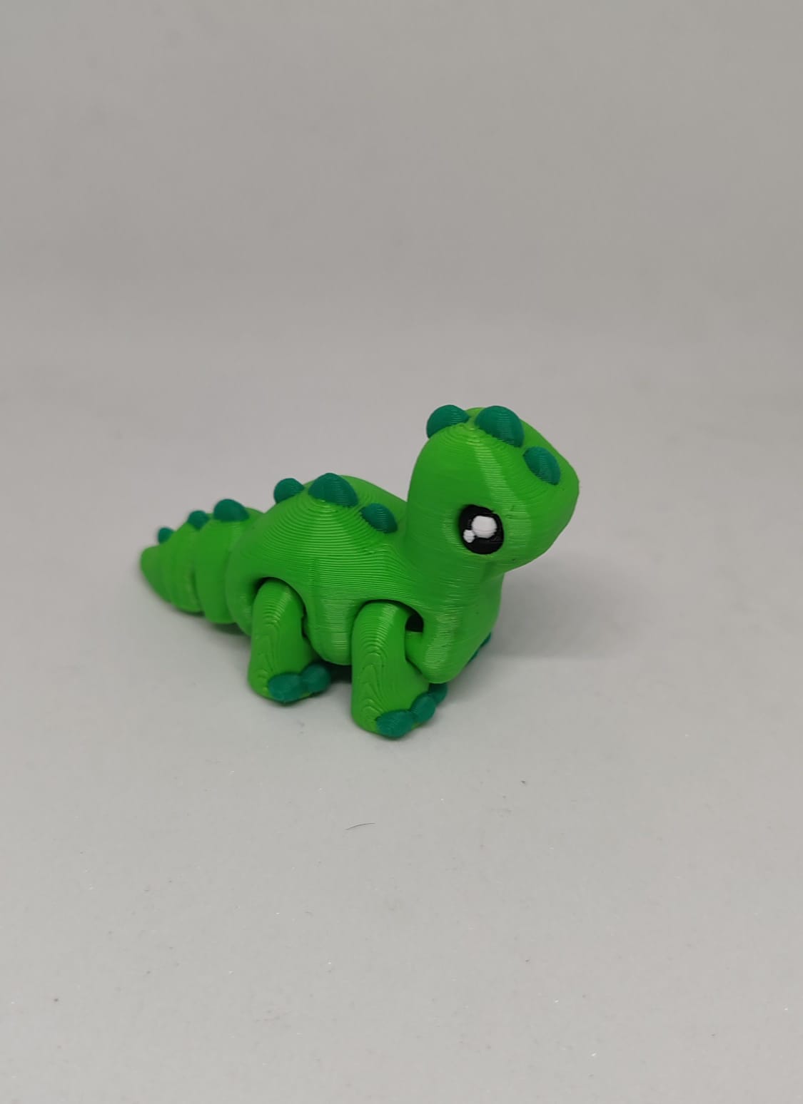Small green Brontosaurus dinosaur hatchling with long articulated neck