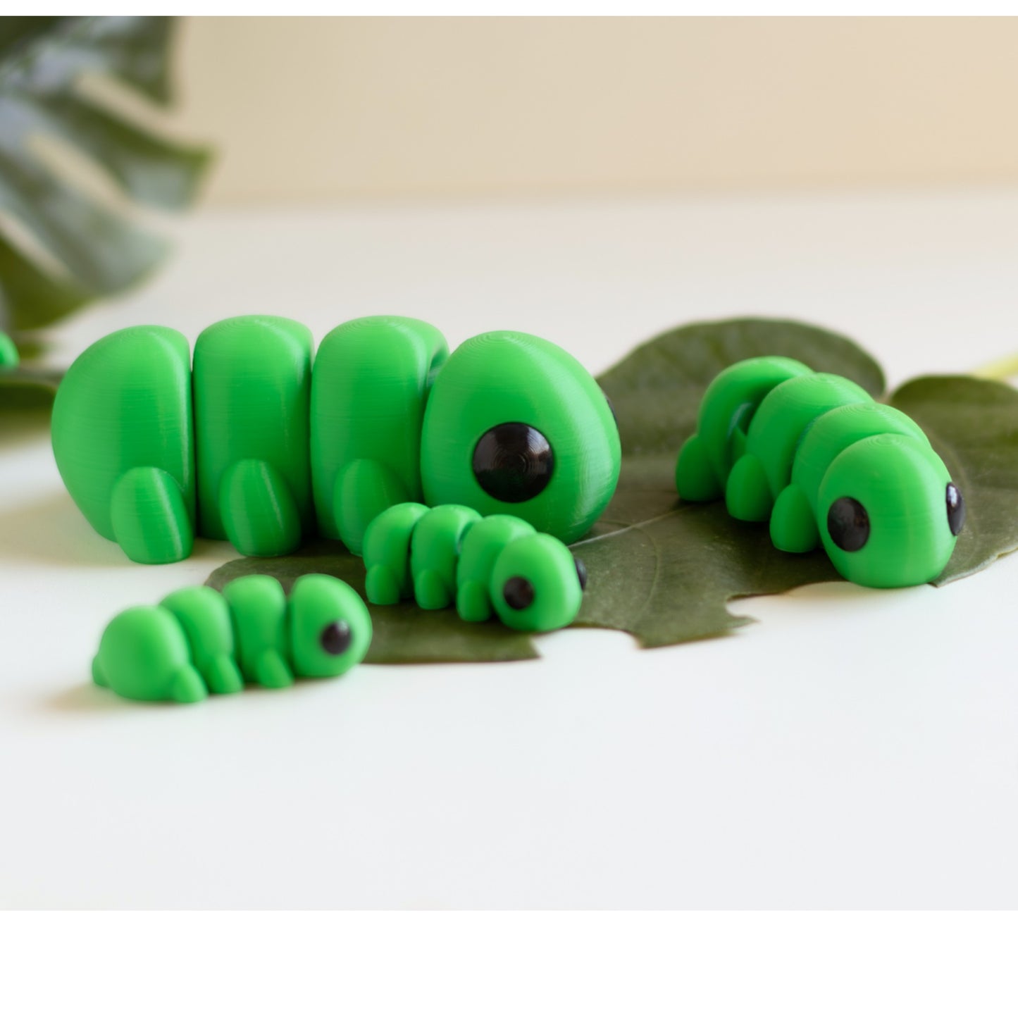 Green flexible caterpillar figurine with segmented body