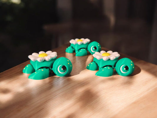 Three daisy flower themed articulated turtles with white and yellow petals