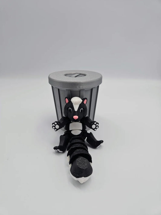 Black and white articulated skunk figurine in trash can