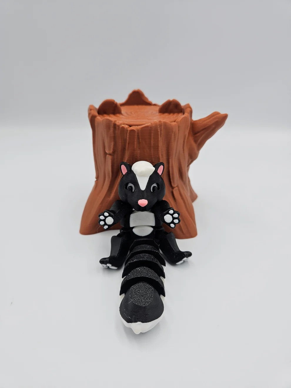 Skunk collectible on tree stump display base with white stripe