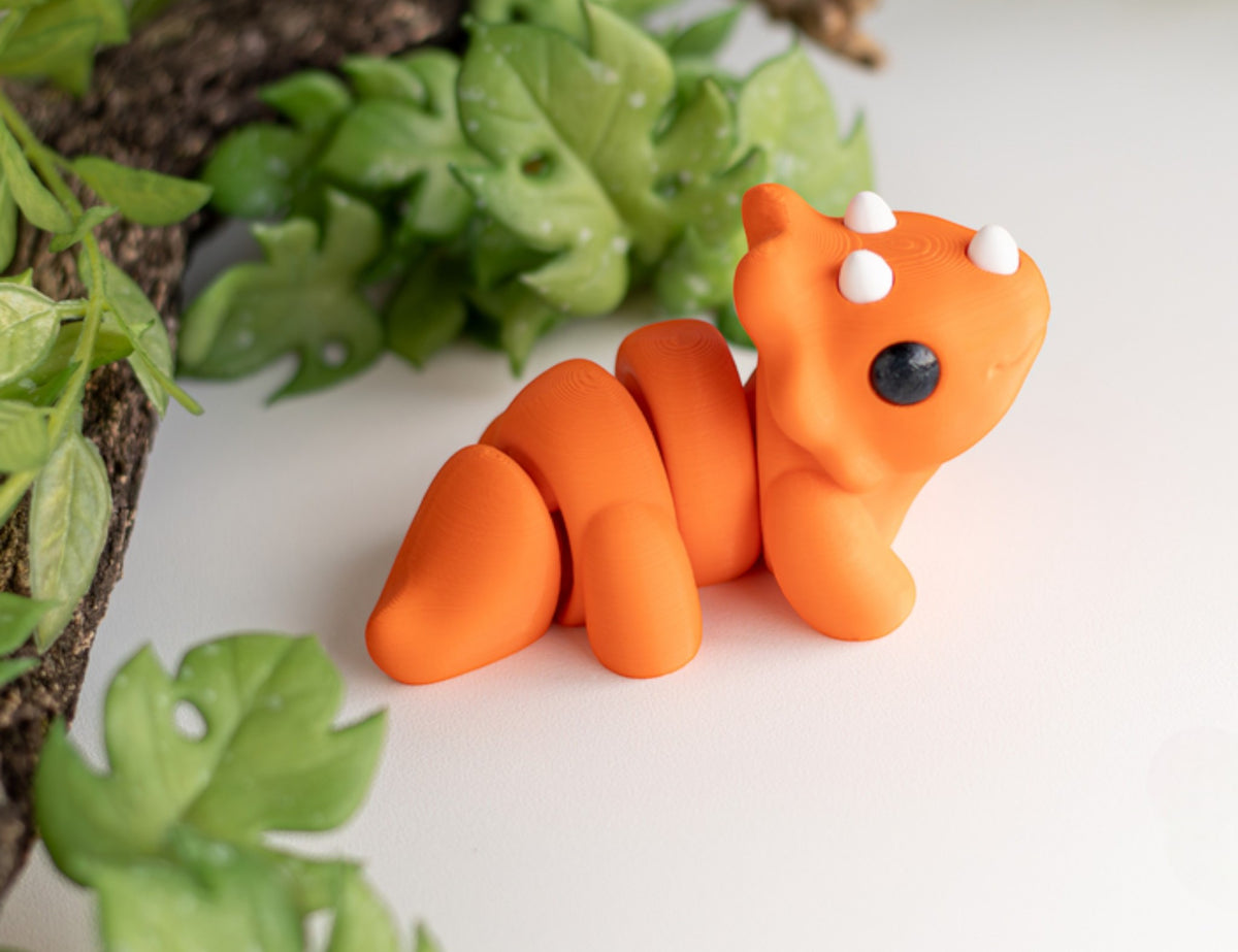 Orange flexible Triceratops dinosaur figurine with three horns