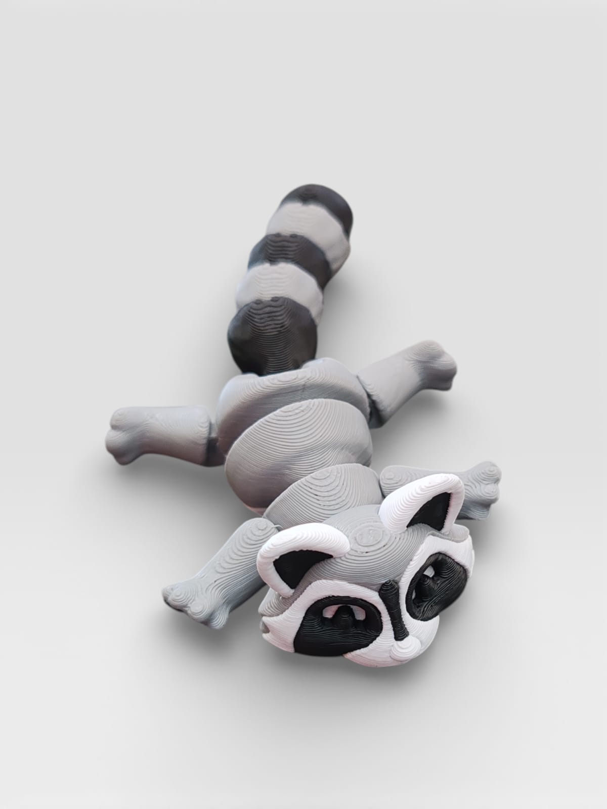 Raccoon figurine display with trash can base