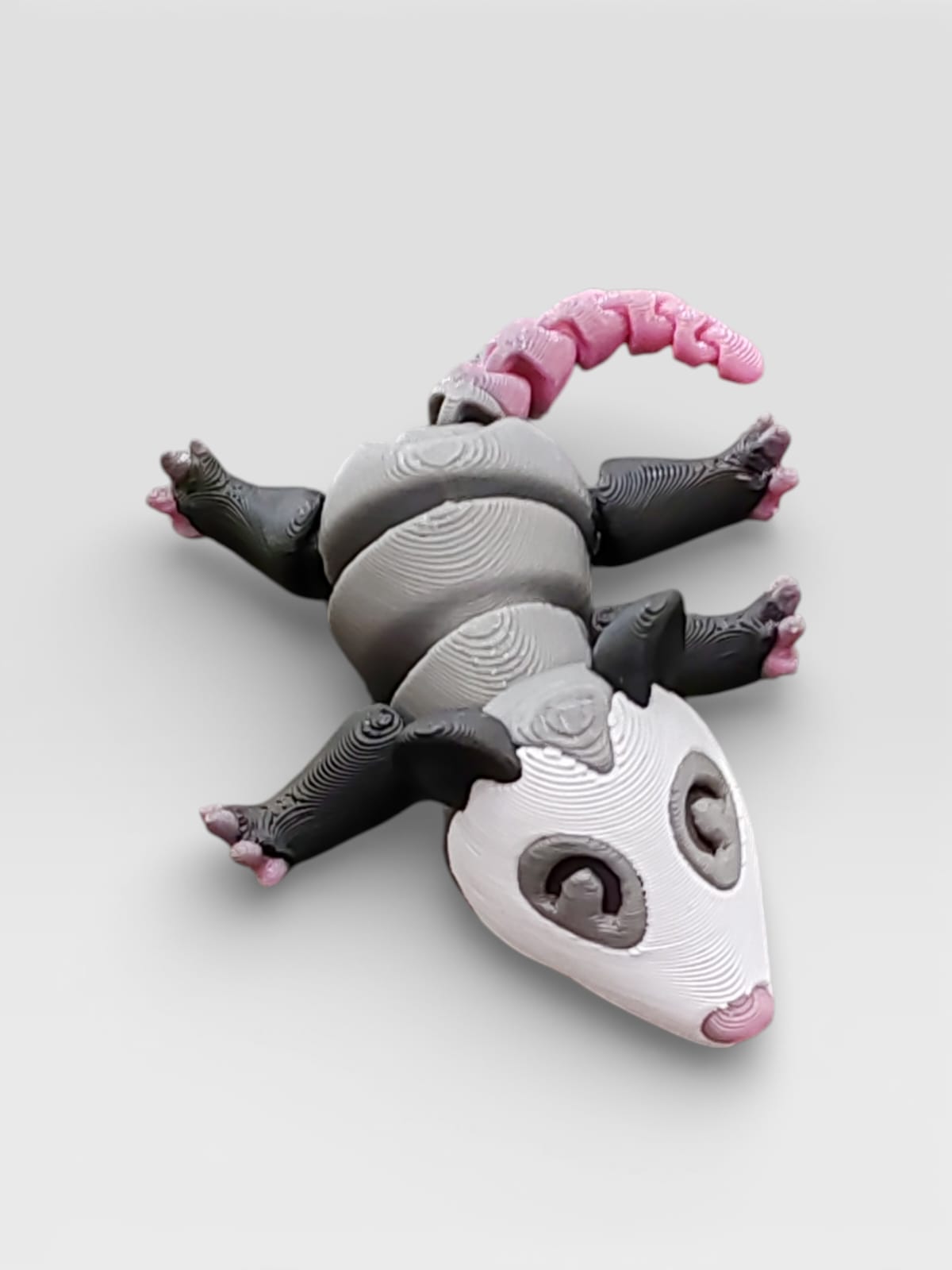 Gray possum on display base showing poseable design