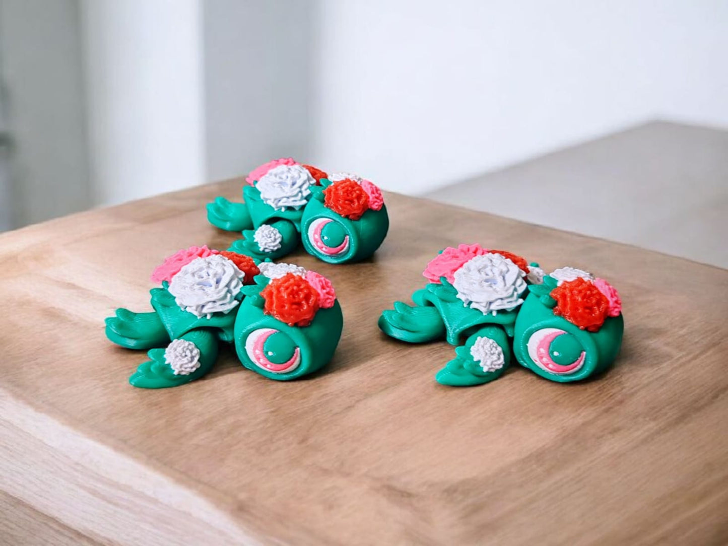 Three colorful flower themed articulated turtles with petal designs